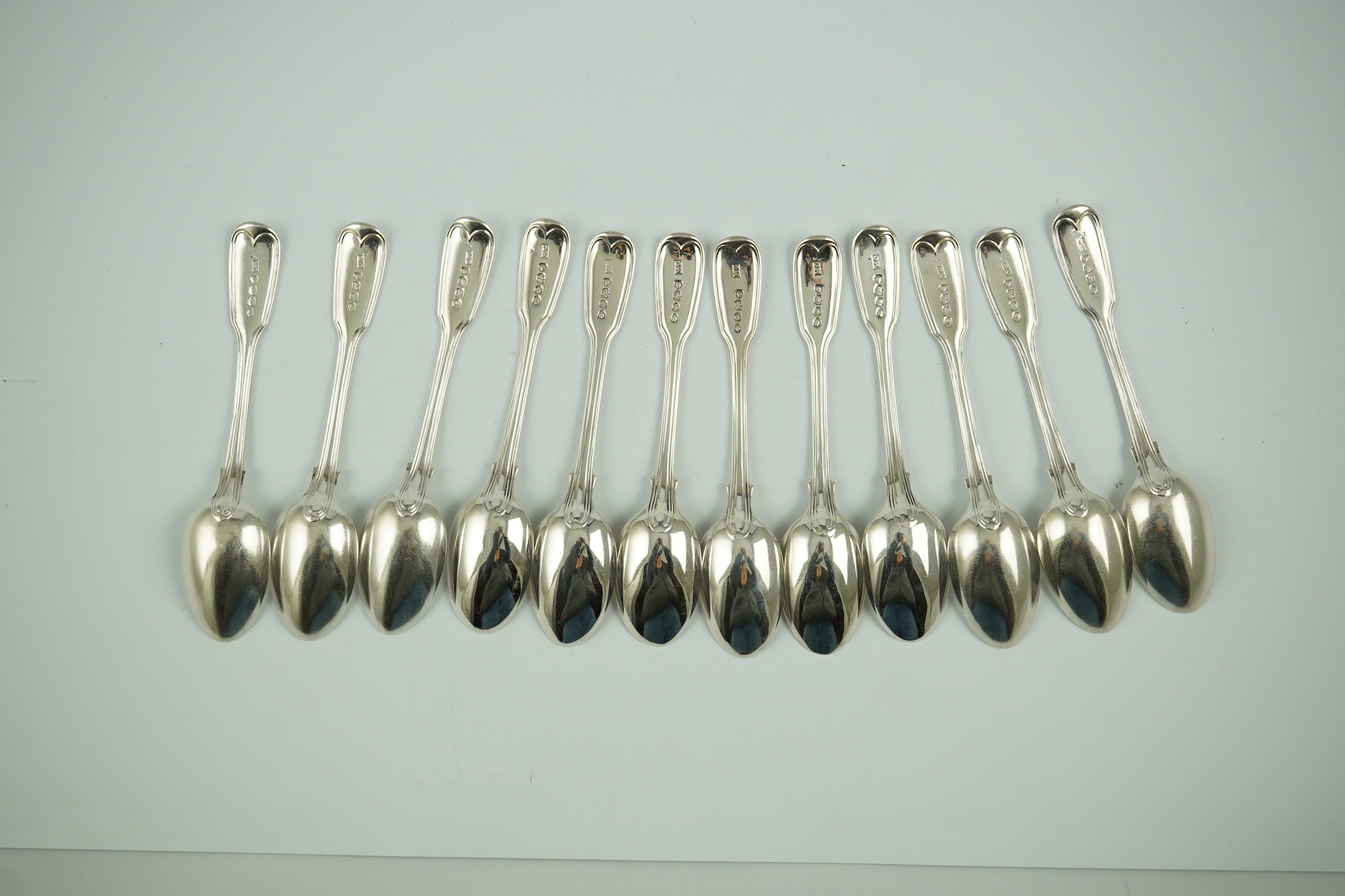 Two sets of six William IV silver fiddle and thread pattern teaspoons, one with engraved crest, William Chawner II, London, 1831 and Mary Chawner, London, 1836